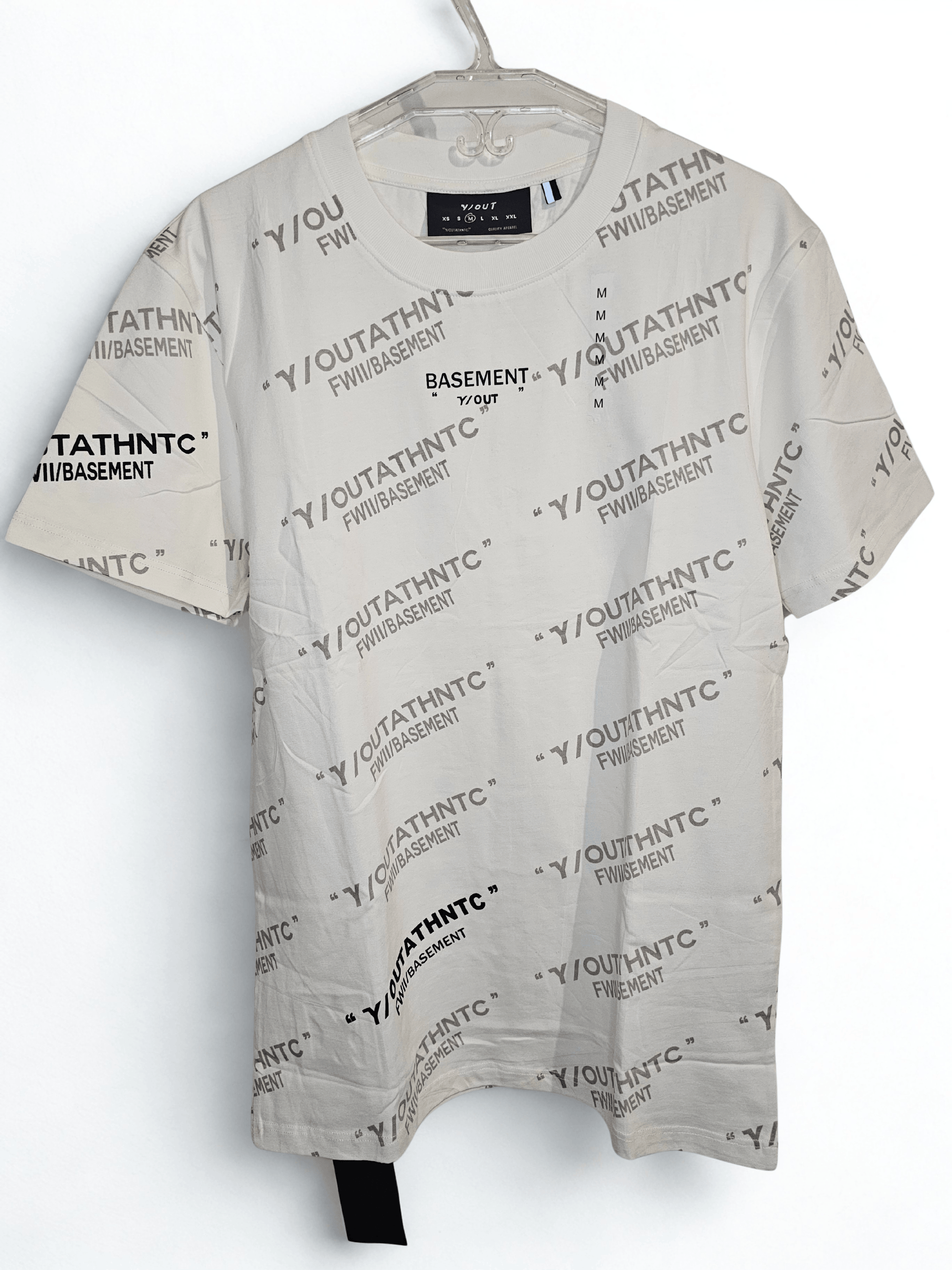 Camisa blanca Y/out con estampado repetitivo de logotipos en negro, estilo urbano y moderno. Ideal para outfits casuales y cómodos.